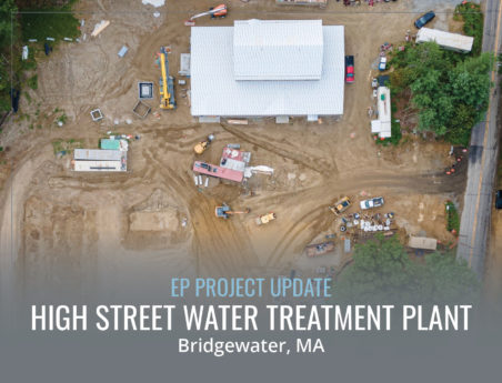 Aerial view of a construction site featuring a large building at the top and construction equipment throughout the site